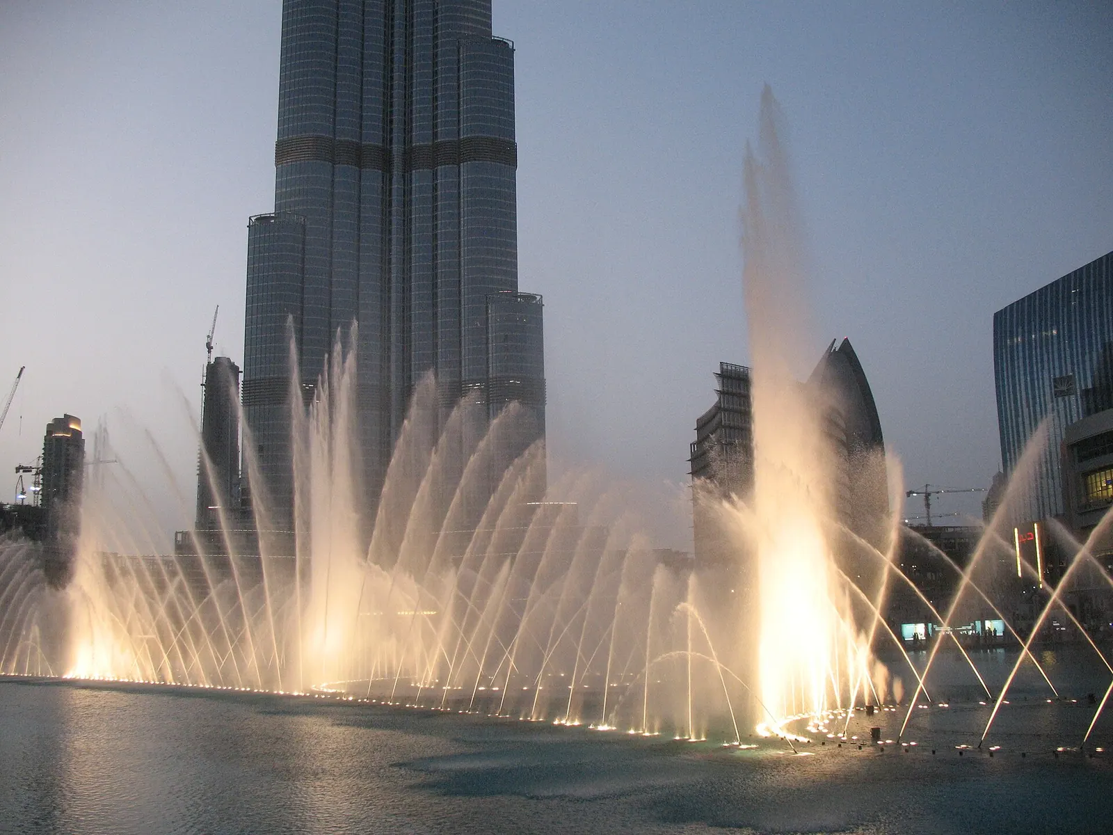 Couple watching the Dubai Fountain show at dusk, part of a romantic honeymoon itinerary